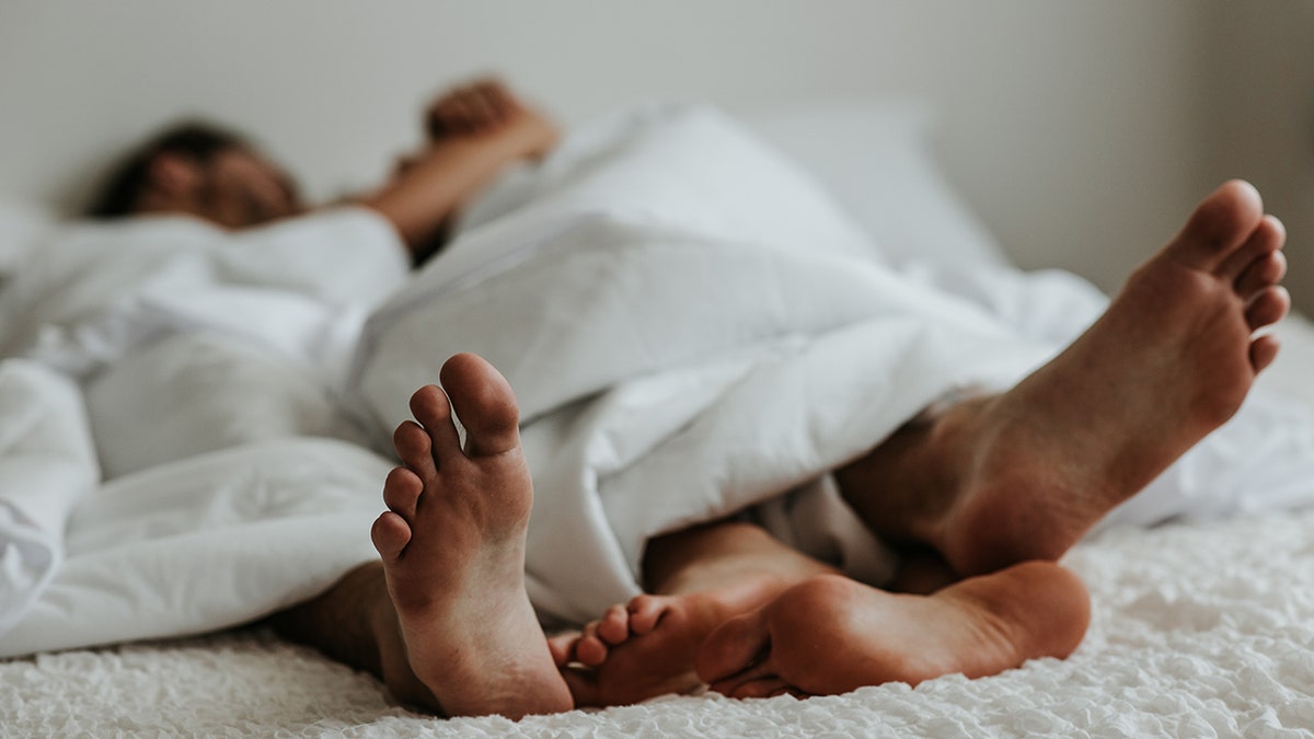 The couple's feet at the end of the bed