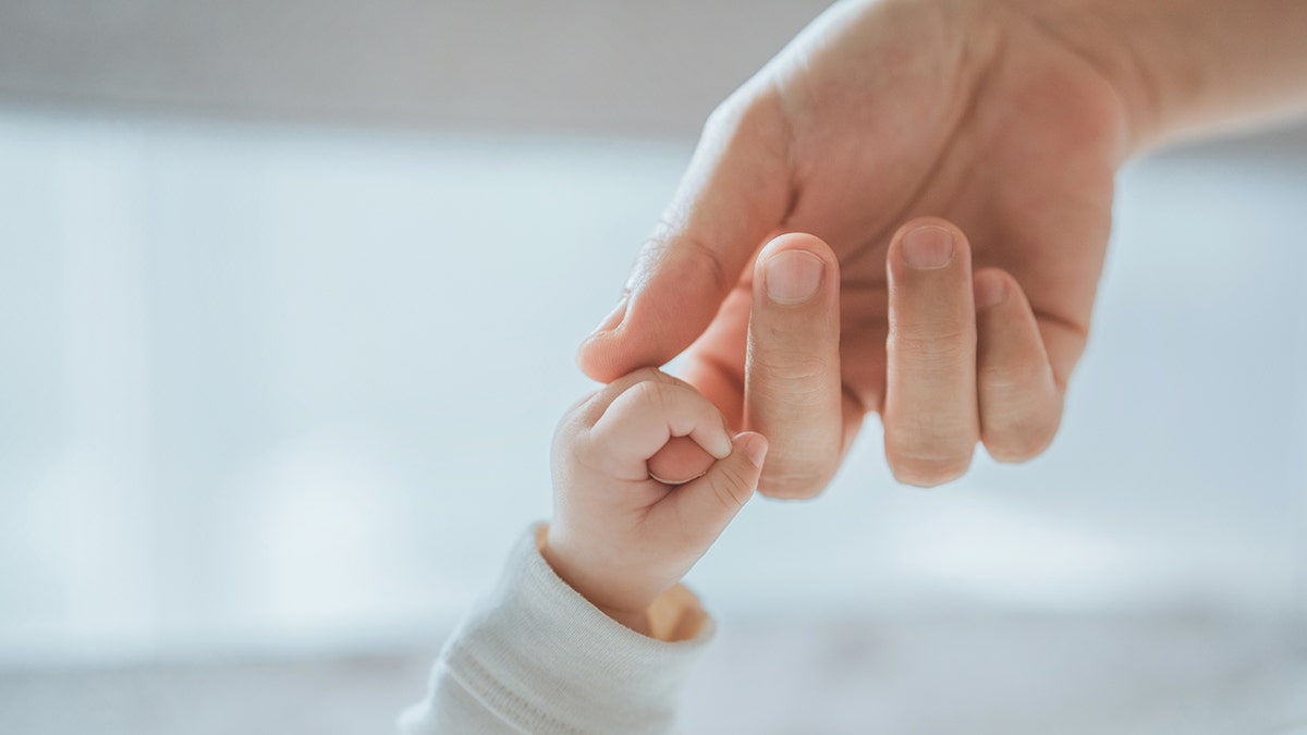 Foreground with baby hand with mother's hand